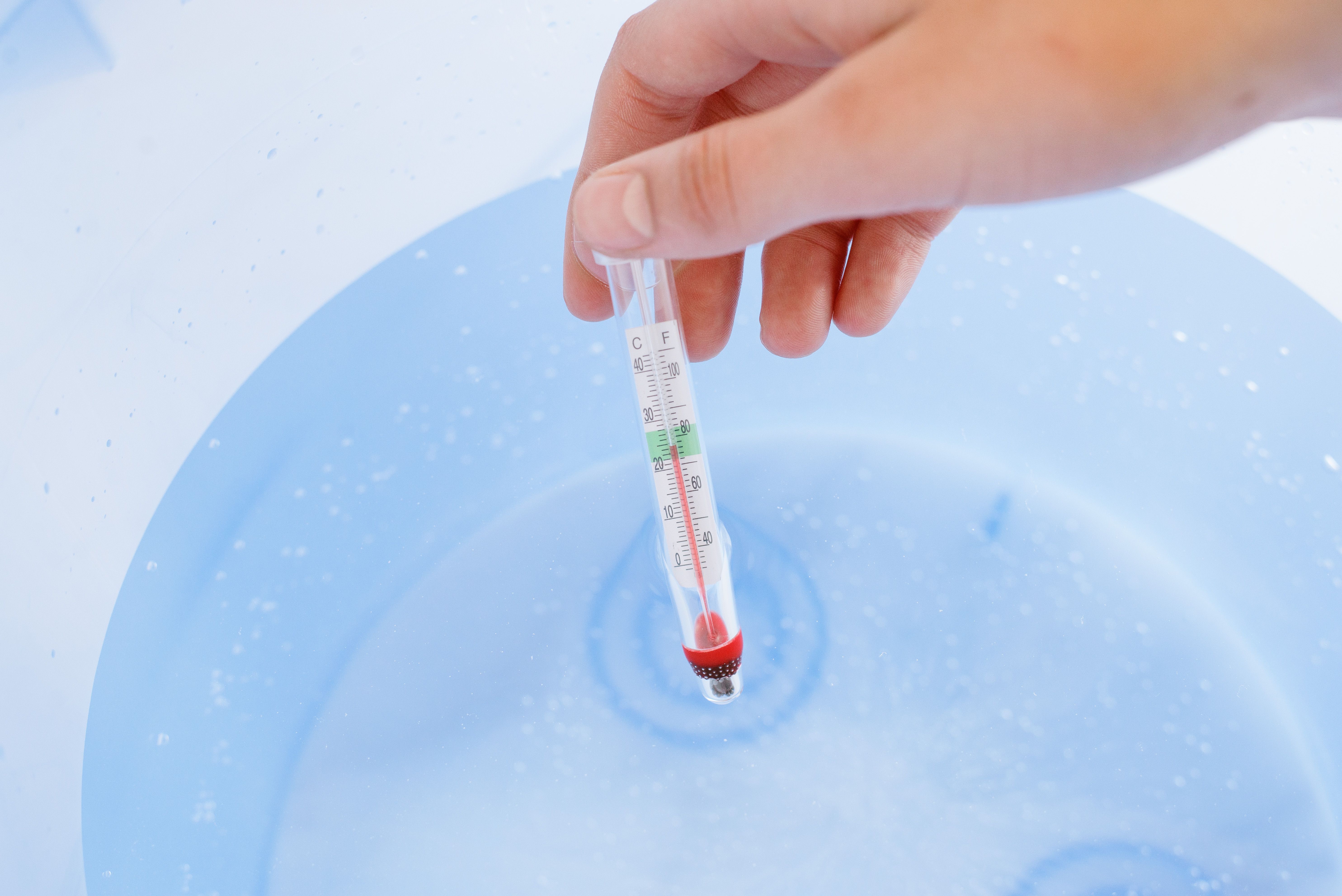Thermomètre d'aquarium mesurant la température de l'eau du robinet dans le seau